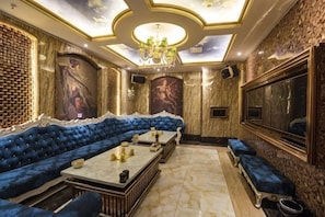 A luxurious room with a blue sofa, a marble floor, and a chandelier. - Xiyan International Hotel (Huining)
