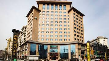 A multi-story hotel with a prominent entrance, large windows, and a central courtyard.