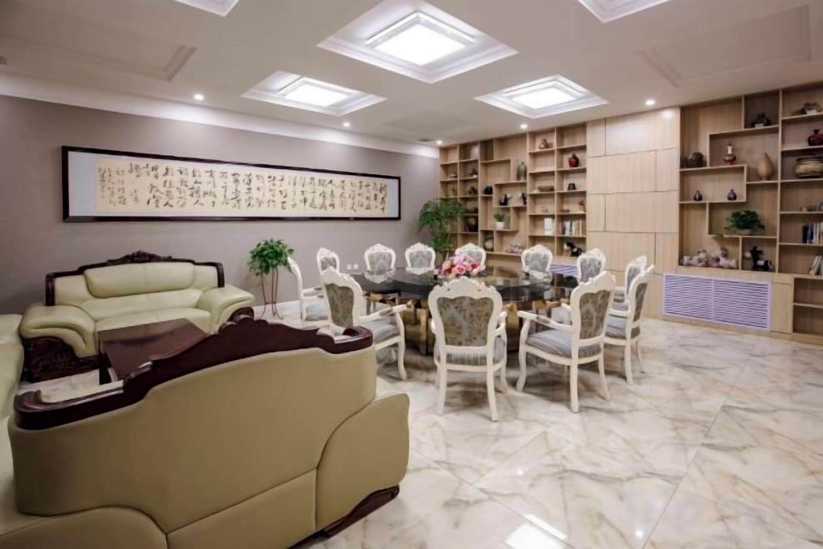 Una sala de estar con sofá, mesa de comedor, sillas y estantería.