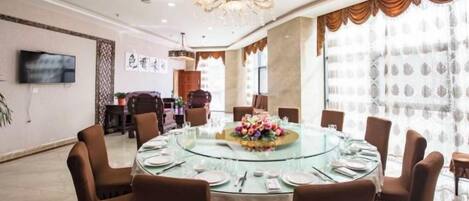 A dining room with a round table, chairs, and a chandelier.
