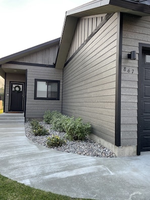 Stylish home with a garden and a black door with a glass panel.