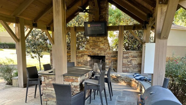 An outdoor patio with stone flooring, a stone fireplace, and a grill. - Walk to Ole Miss Games, Oxford Square - 2 Master Suites - Patio - Near Stadium! (Oxford)