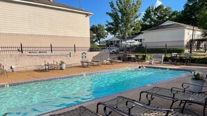 A swimming pool with lounge chairs and a fenced area, surrounded by buildings. - Walk to Ole Miss Games, Oxford Square - 2 Master Suites - Patio - Near Stadium! (Oxford)