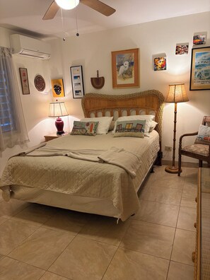 Une chambre à coucher avec un lit, une table de chevet, une lampe et une chaise.