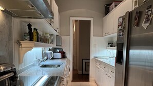 A modern kitchen with stainless steel appliances, white cabinetry, and a marble countertop. - Beautiful apartment in the heart of Buenos Aires Art (CABA)