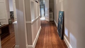 A hallway with wooden flooring, white walls, and built-in shelving units. - Beautiful apartment in the heart of Buenos Aires Art (CABA)