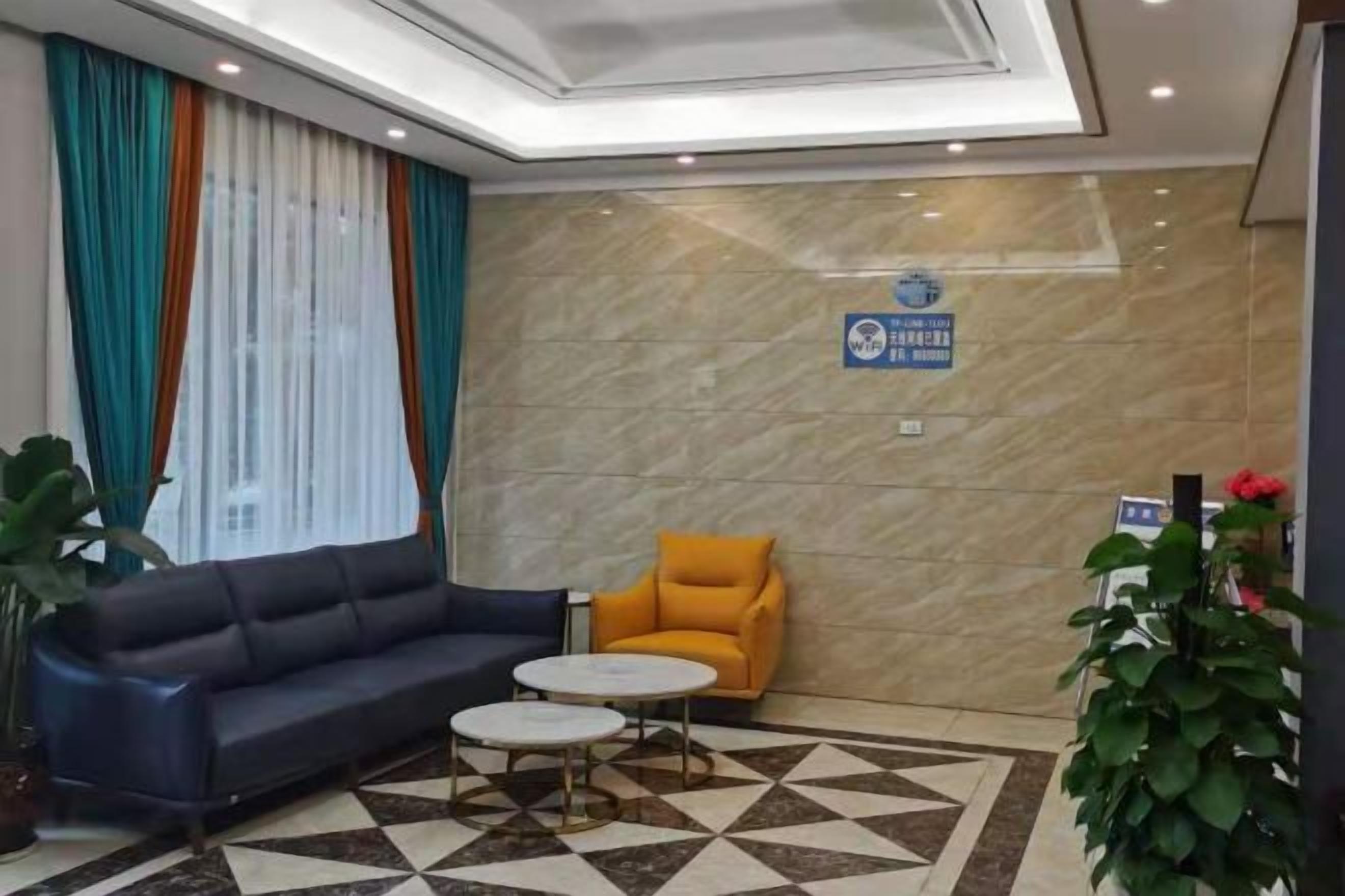 Un hall de hotel con un sofá, un sillón y una pequeña mesa redonda.