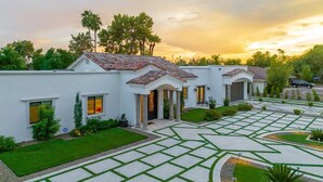A modern house with a tiled roof, a well-maintained lawn, and a driveway with geometric patterns. - Resort-Style Escape with Heatable Pool, Games & Modern Design (Scottsdale)