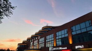A modern building with multiple floors and large windows, featuring signage for 'City Culture Space Dream &'. - University Hotel (Binzhou)