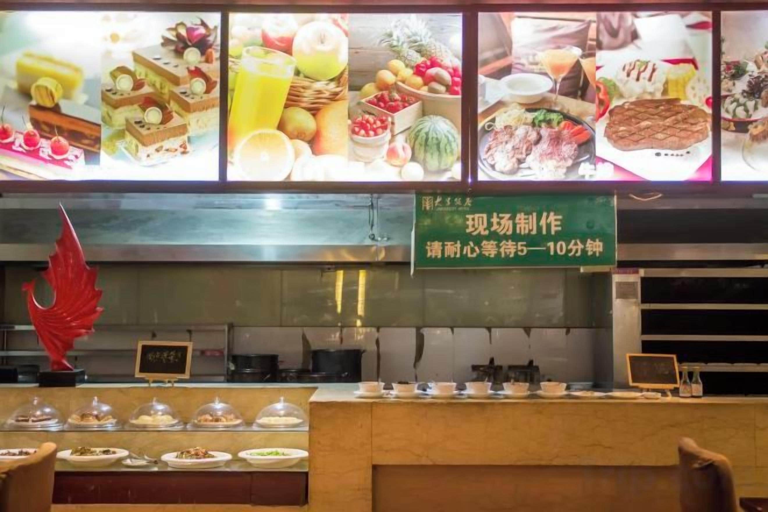 A food counter with a variety of dishes displayed and a sign indicating a 5-10 minute wait time.