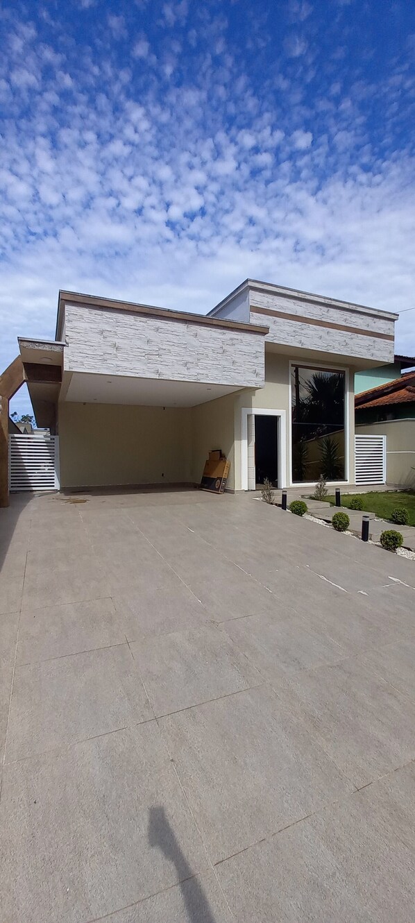 Een modern huis met een ruime patio, een garage en een verzorgd gazon.