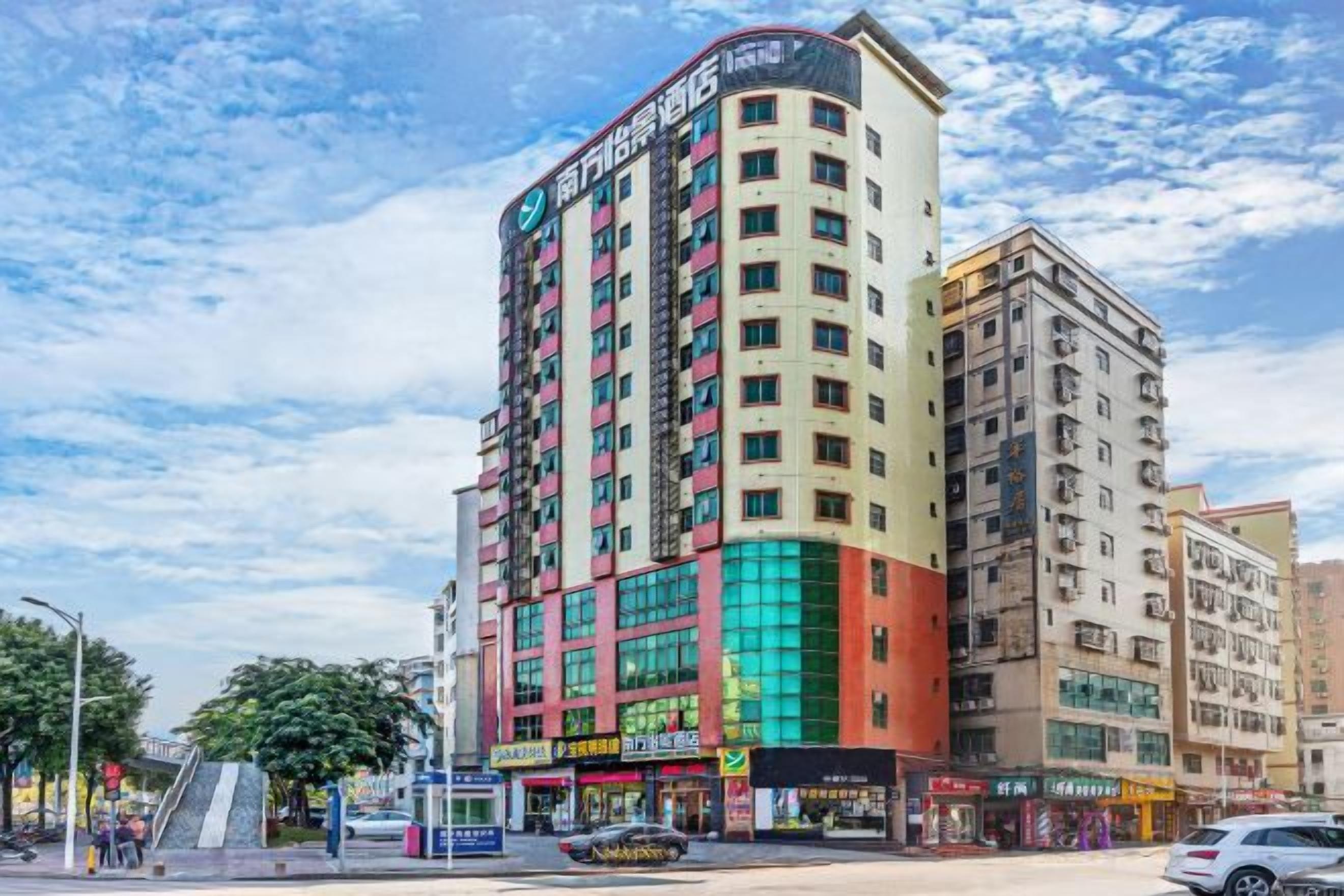 A multi-story hotel with a prominent corner location, featuring a mix of commercial spaces on the ground floor and residential units above.