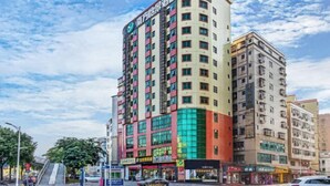 A multi-story hotel with a prominent sign on the corner, featuring a modern design with large windows and a mix of colors on the facade. - Nanfang Yijing Hotel (Shenzhen Baoan International Airport Gushu Subway Station store) (Shenzhen)