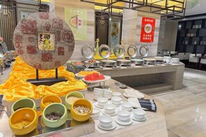 A buffet setup with various food items and dishes. - Sunwu Hot Spring International Hotel (Huimin)