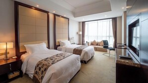 A hotel room with two beds, a TV, a desk, and a large window. - Sunwu Hot Spring International Hotel (Huimin)