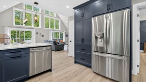 Una cocina moderna con armarios oscuros, electrodomésticos de acero inoxidable y una isla grande.