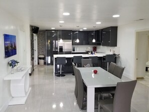 Enjoy meals in the kitchen and dining area with dark cabinetry, stainless steel appliances, and a dining table for four.