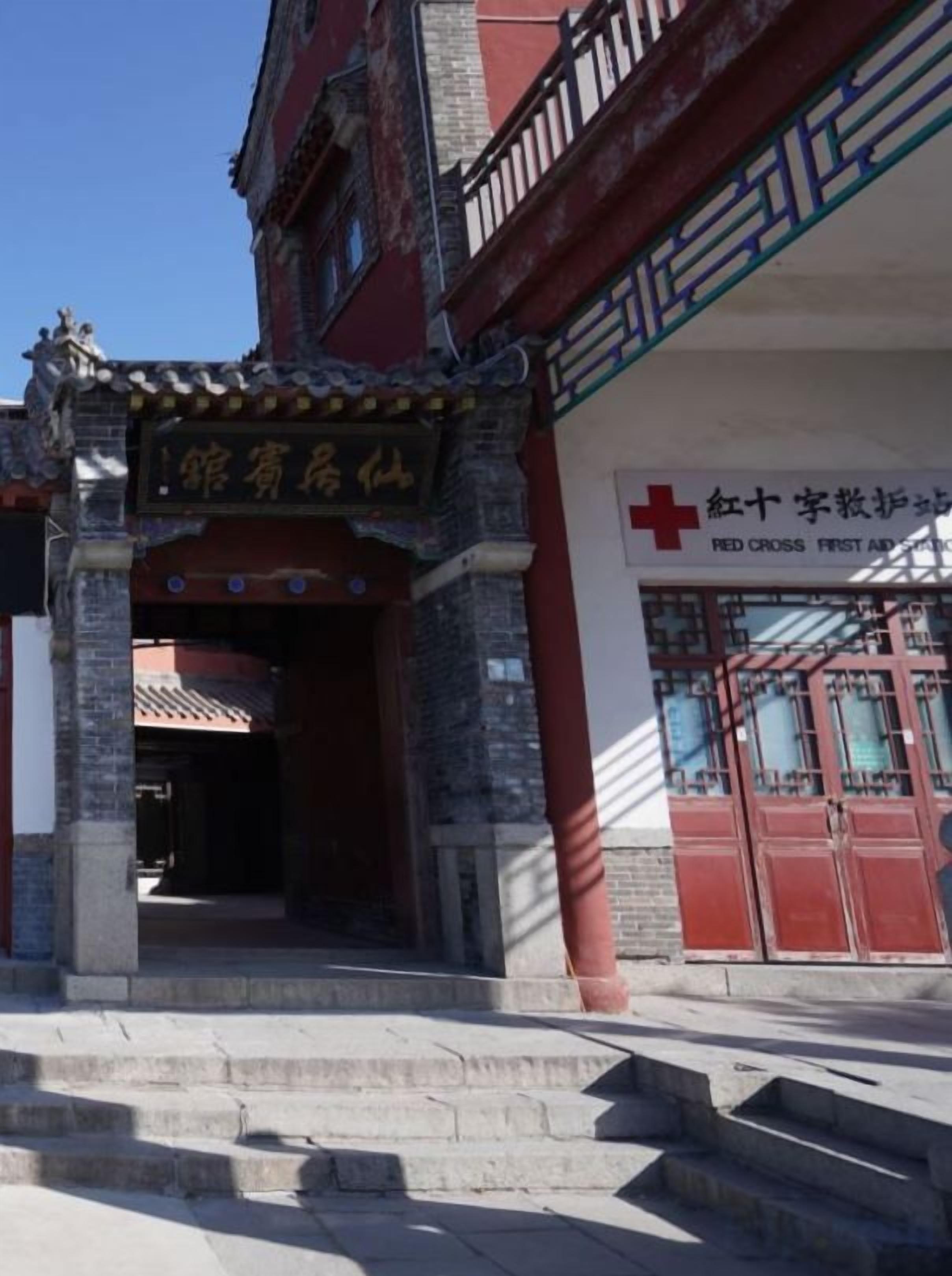 A traditional building with a red cross sign indicating a medical facility.