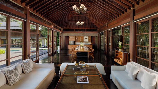 A spacious room with a high ceiling, wooden beams, and large windows. - Villa Amita by Nakula (Kerobokan)