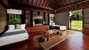 A modern bedroom with a wooden ceiling, a large window, a bed, a sofa, and a TV. - Villa Amita by Nakula (Kerobokan)
