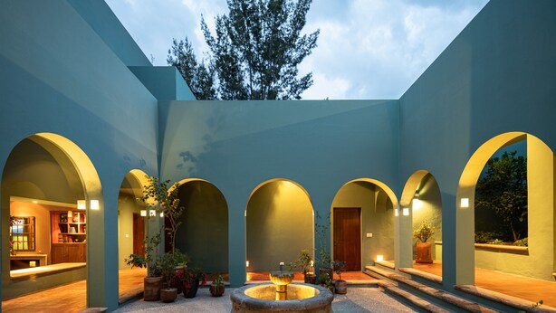 A courtyard with a central fountain, surrounded by arched walkways and potted plants. - Balcones 5BR Villa | Weddings | Stunning Views (San Miguel de Allende)