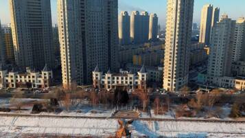 Un complejo residencial de edificios de gran altura, con varios edificios de apartamentos, una plaza central y suelo cubierto de nieve.