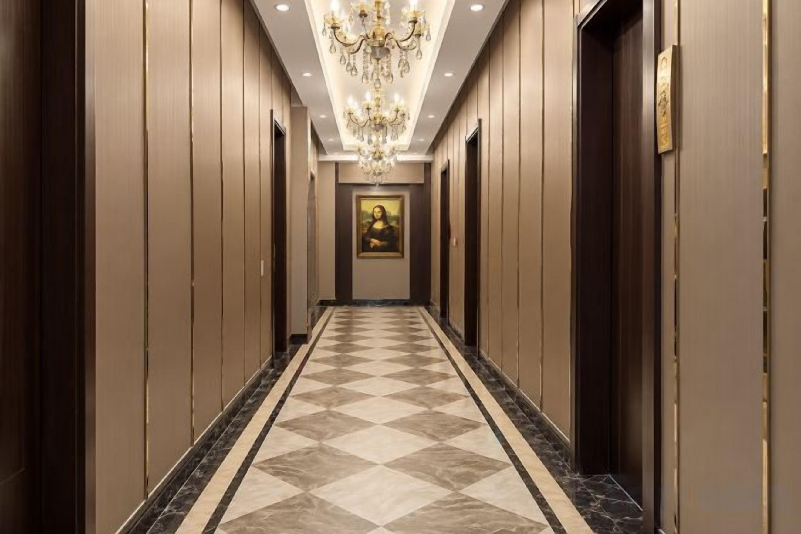 Un pasillo de hotel con piso de cuadros, un candelabro y puertas a ambos lados.