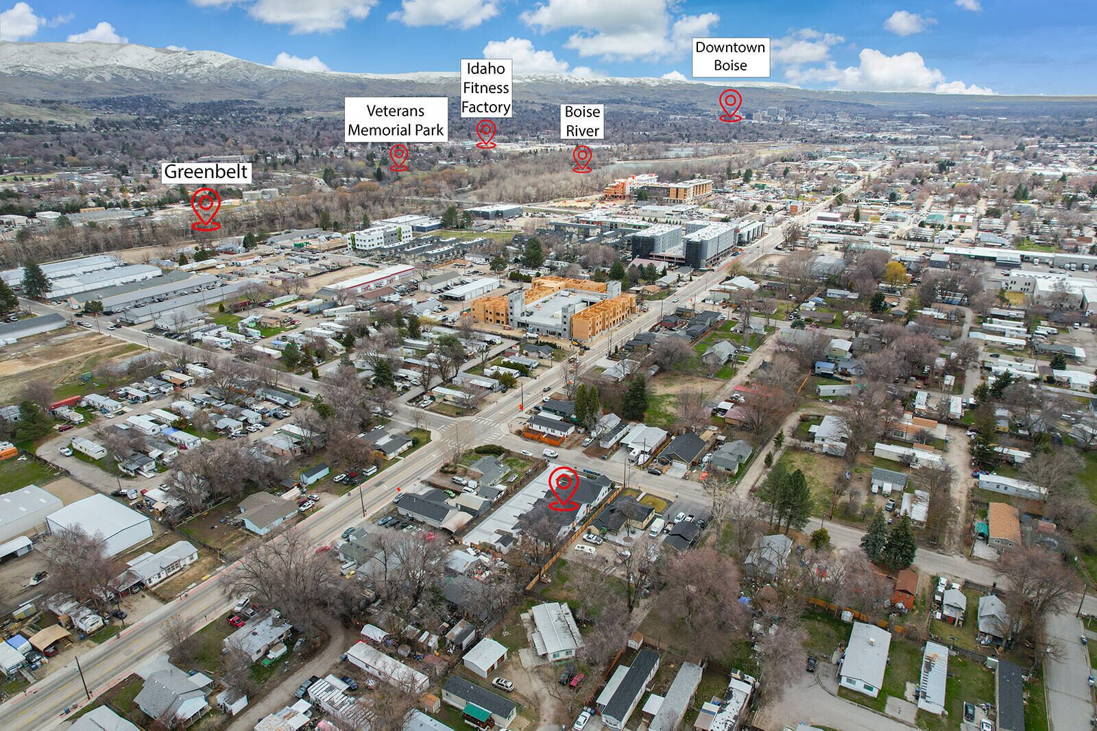 Vista aérea de una zona residencial con casas unifamiliares y viviendas modulares, carreteras y edificios industriales.