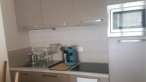 Eine moderne Küche mit Edelstahlgeräten, einer Spüle und einer Kaffeemaschine.