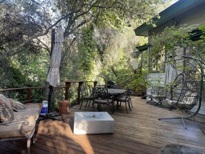 Une terrasse en bois aménagée avec du mobilier d’extérieur, notamment un canapé, des fauteuils et une table.