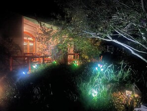 Experience the warm glow of this inviting building, surrounded by a serene garden.
