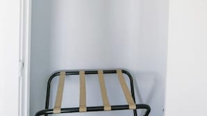 A white closet with a hanging rack and an iron on the top shelf. - Fillmore Lodge:Comfortable Queen Room - Best Price (Fillmore)