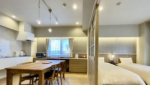 Quarto de hotel compacto com cozinha compacta, espaço para refeições e uma cama.