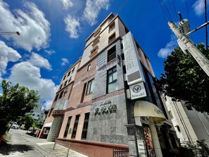 Un edificio a più piani con un cartello ben visibile per "Komugi Tenbikan".