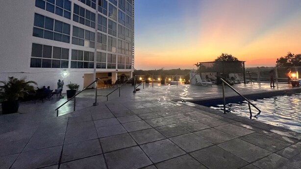 A modern building with a pool area, including a sunken seating area and a water feature. - Apartment in Coronado: Just steps from the beach, restaurants, cafes, and bars (Las Lajas)
