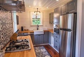 Enjoy cooking in this well-equipped kitchen with a stainless steel refrigerator, gas stove, and oven.