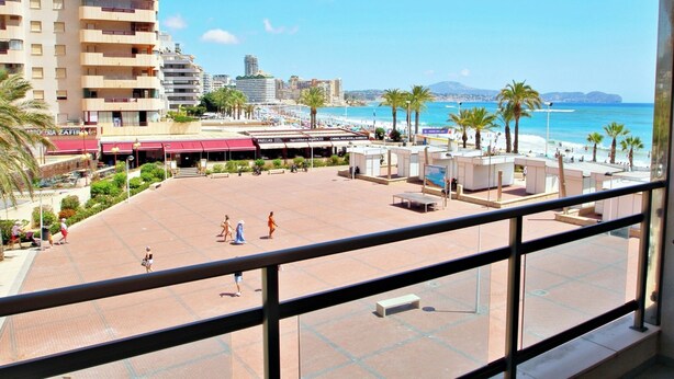 A beachside promenade with a view of the sea, palm trees, and a hotel building. - Xavier - oceanfront apartment with sea views in Calpe (Calpe)