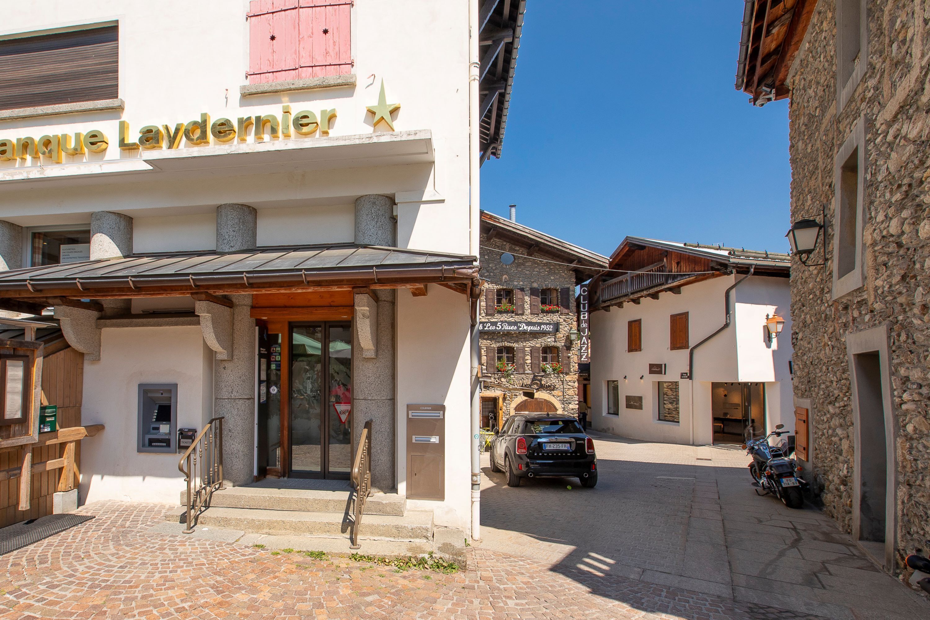 Un hotel con fachada de piedra, entrada de madera y un letrero que dice "Hotel Laydernier".
