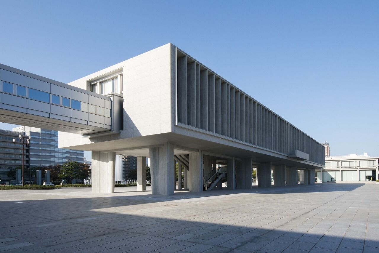 Un edificio moderno con techo plano, ventanas amplias y un corredor cubierto.
