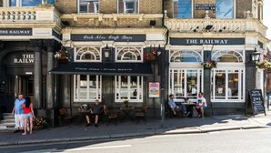 Een pub genaamd 'Cask Ales Craft Beers' met terras en een bord waarop '2 voor 1' aanbiedingen staan.