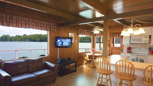 A cozy cabin interior with a living room, a dining area, and a kitchen. - New Listing! Adorable lakefront cabin, private dock, hot tub, gas grill, amazing views (Florence)
