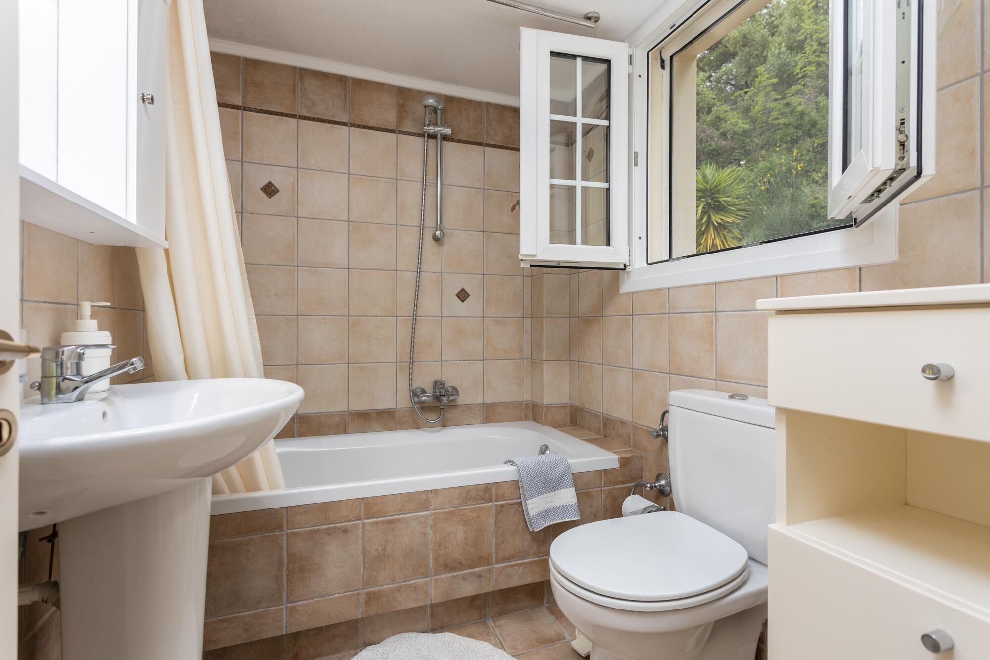 A bathroom with a bathtub, toilet, and sink.