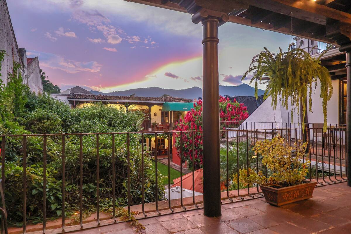 Un patio con vistas a montañas, una pérgola y una planta en maceta.