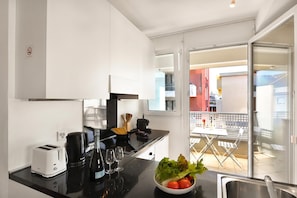 A modern kitchen with a toaster, coffee maker, and wine glasses on the counter.