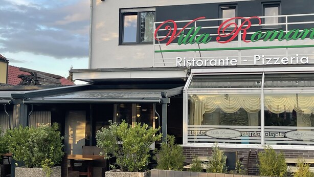 A building with a sign reading "Villa Romana Ristorante - Pizzeria" and outdoor seating. - Hotel Restaurant Villa Romana (Hainburg)