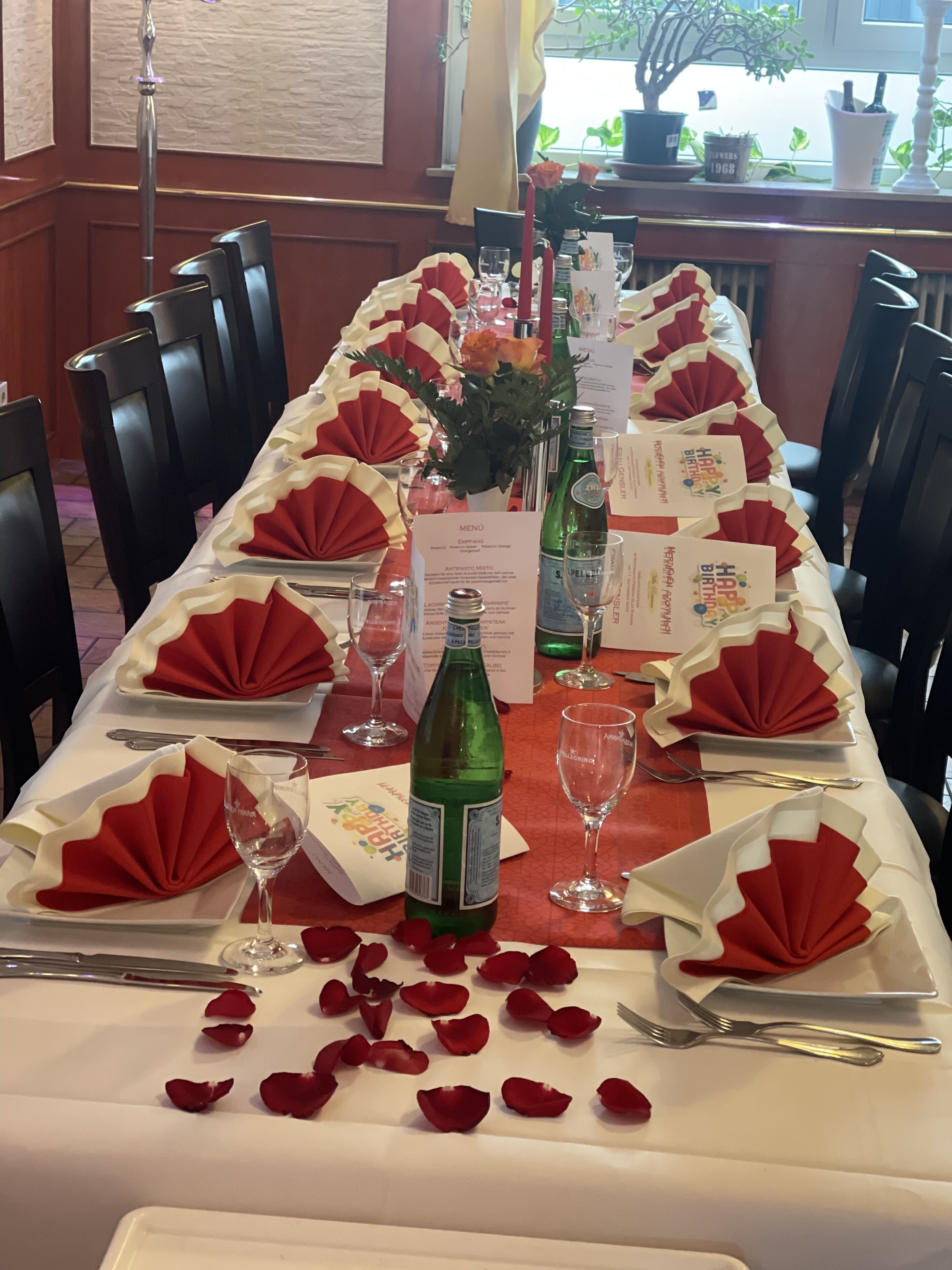 A table set for a formal dining experience with a menu, wine glasses, and a bottle of wine.