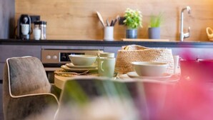 A modern kitchen with a wooden backsplash, a stove, and various kitchen utensils and appliances.