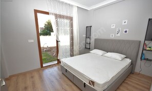 Relax in a serene bedroom with a large bed and access to an outdoor area.