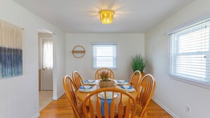 Comedor con una mesa redonda dispuesta para seis personas, rodeada de sillas de madera.
