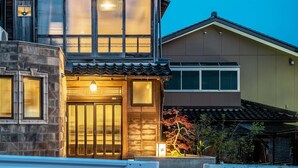 A traditional Japanese house with a wooden facade, large windows, and a tiled roof. - Sansuikyo Machiya House (Kanazawa)